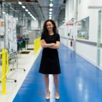 Confident female engineer standing in a high-tech industrial facility, showcasing engineering profession.